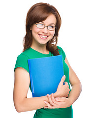 Image showing Young skinny student girl is holding exercise book