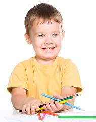 Image showing Little boy is holding color pencils