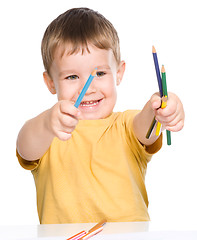 Image showing Little boy is playing with color pencils