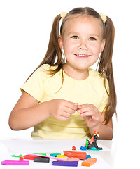 Image showing Little girl is playing with plasticine