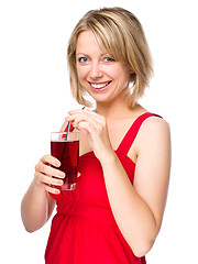 Image showing Young woman is drinking cherry juice
