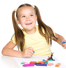 Image showing Little girl is playing with plasticine