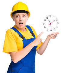 Image showing Young construction worker is pointing at clock