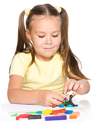 Image showing Little girl is playing with plasticine