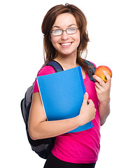 Image showing Young student girl is holding book and apple