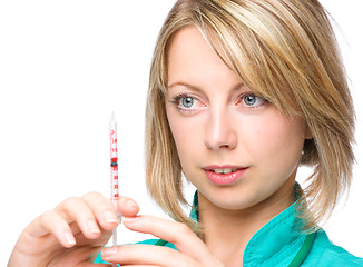 Image showing Young nurse is preparing syringe for injection