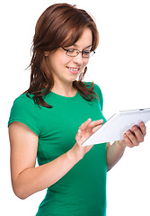 Image showing Young cheerful woman is using tablet