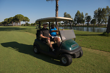 Image showing golf players driving cart at course