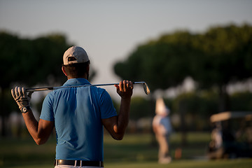 Image showing golfer from back at course looking to hole in distance