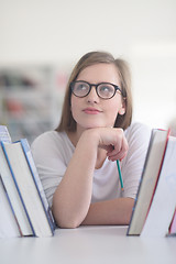 Image showing portrait of famale student selecting book to read in library