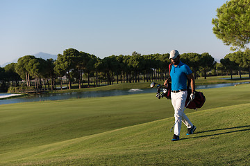 Image showing golf player walking and carrying bag