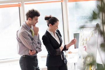 Image showing young couple working on flip board at office