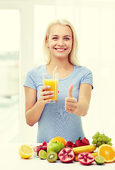 Image showing woman drinking fruit juice and showing thumbs up