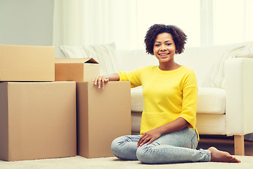 Image showing happy african woman with cardboard boxes at home
