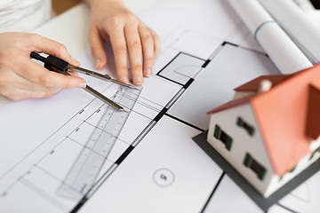 Image showing close up of hands with compass measuring blueprint