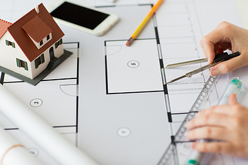 Image showing close up of hands with compass measuring blueprint