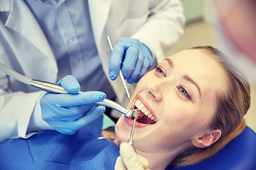 Image showing close up of dentist treating female patient teeth