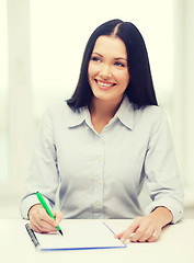 Image showing smiling businesswoman or student studying