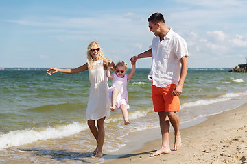 Image showing happy family in sunglasses walking on summer beach