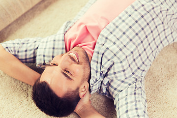 Image showing happy man lying carpet or rug at home
