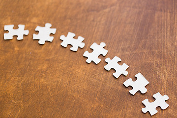 Image showing close up of puzzle pieces on wooden surface