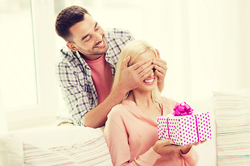 Image showing happy man giving woman gift box at home