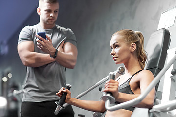 Image showing man and woman flexing muscles on gym machine