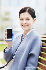 Image showing young smiling businesswoman showing smartphone