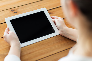 Image showing close up of woman with tablet pc on wooden table