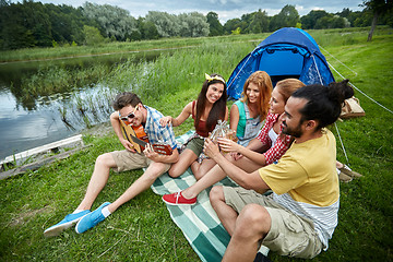 Image showing happy friends with drinks and guitar at camping