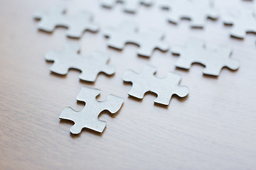 Image showing close up of puzzle pieces on wooden surface