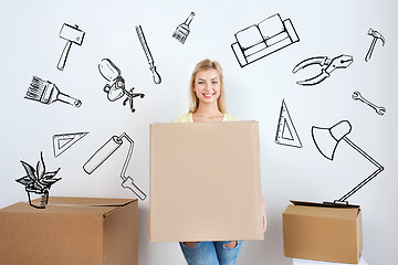 Image showing smiling young woman with cardboard box at home