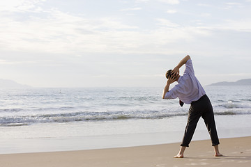 Image showing Businessman doing exercises on beach