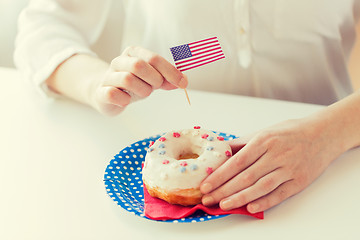 Image showing female hands decorating donut with american flag