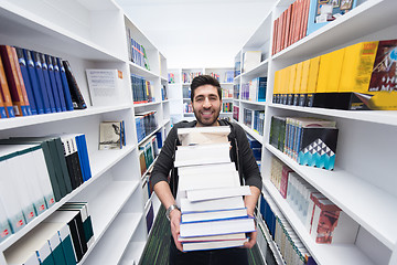 Image showing Student holding lot of books in school library