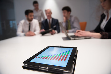 Image showing close up of touchpad with analytics documents at business meetin