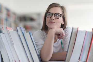 Image showing portrait of famale student selecting book to read in library