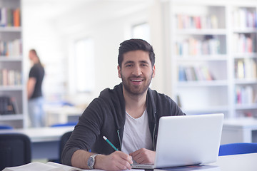 Image showing student in school library using laptop for research