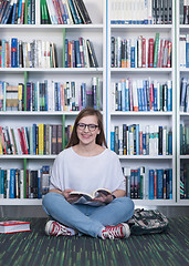 Image showing famale student reading book in library