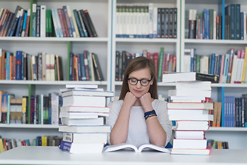 Image showing female student study in library, using tablet and searching for 