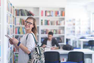 Image showing famale student selecting book to read in library