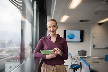 Image showing blonde businesswoman working on tablet at office