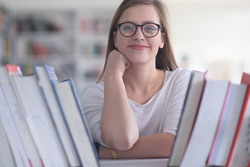 Image showing portrait of famale student selecting book to read in library