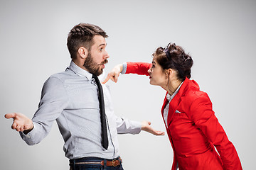 Image showing The angry business man and woman conflicting on a gray background