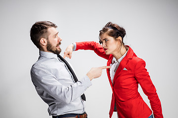 Image showing The angry business man and woman conflicting on a gray background