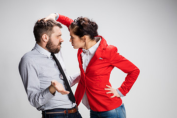 Image showing The angry business man and woman conflicting on a gray background