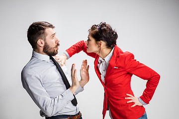 Image showing The angry business man and woman conflicting on a gray background