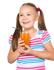 Image showing Little girl is drinking carrot juice