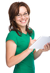 Image showing Young cheerful woman is using tablet