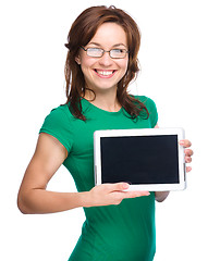 Image showing Young cheerful woman is showing blank tablet